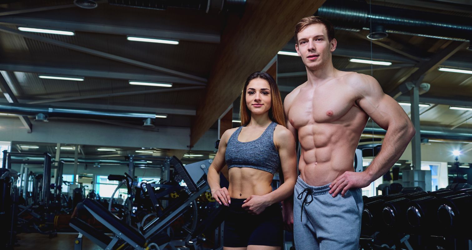 Fit man and woman posing confidently in a gym, representing fitness and strength for gym SEO website background