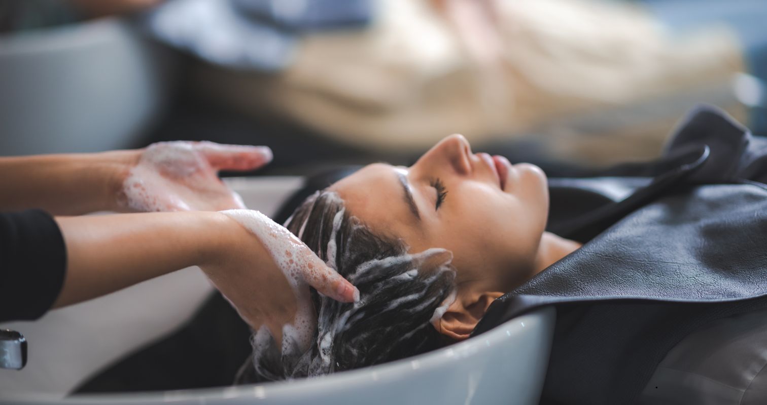 A woman relaxing while getting her hair washed at a salon